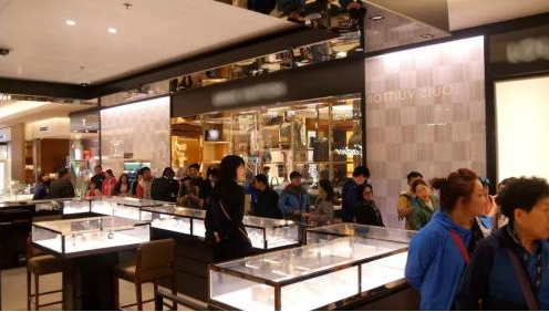 在某奢侈品牌商店内排队购买商品的中国客人